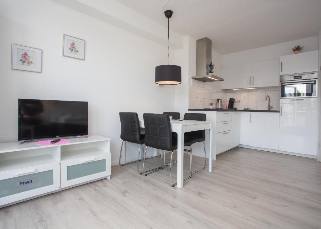 Il comprend une cuisine avec une table et des chaises ainsi qu'une télévision. dans l'établissement Appartement Brink Am Waltenberg 70, à Winterberg