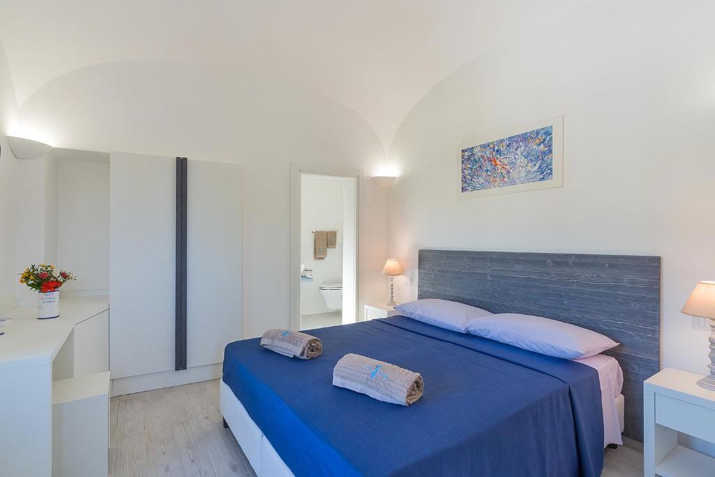 een slaapkamer met een blauw bed met 2 handdoeken erop bij Nitrodi Thermal Relais in Ischia