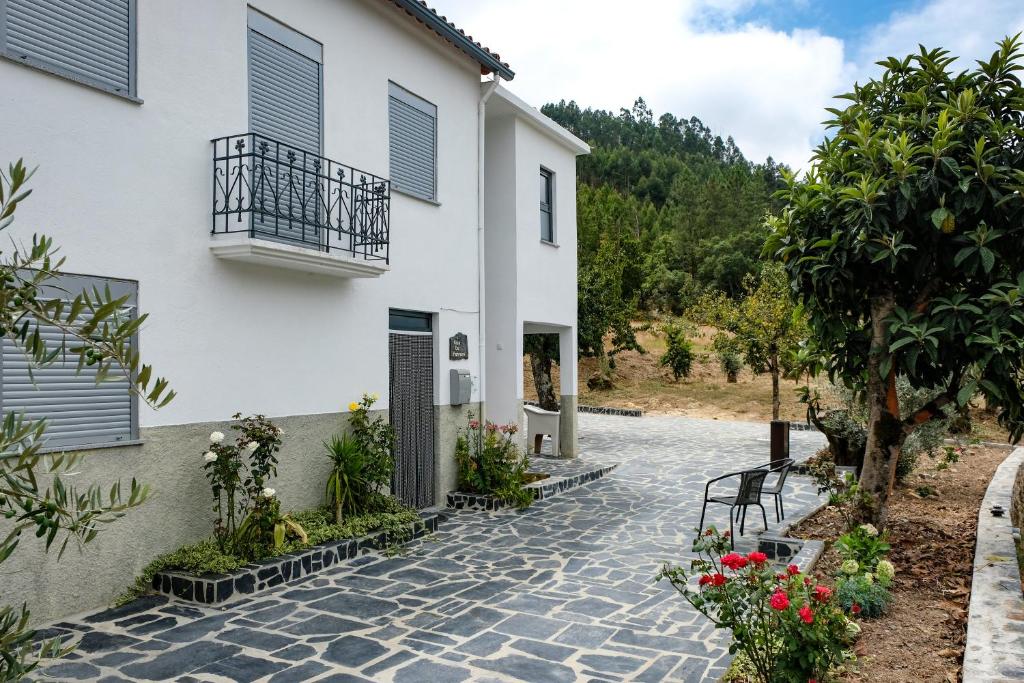 una casa con una pasarela de piedra junto a un edificio en Casa do Ferreiro II en Góis