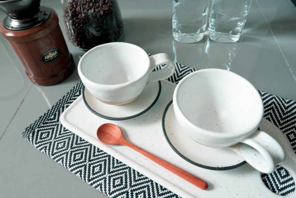 A styled coffee-and-tea setup with two cups on a serving tray.