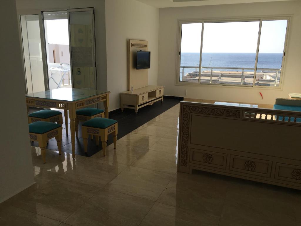 a room with a table and chairs and a view of the ocean at Arabesque Style - 2 appartements in Kelibia