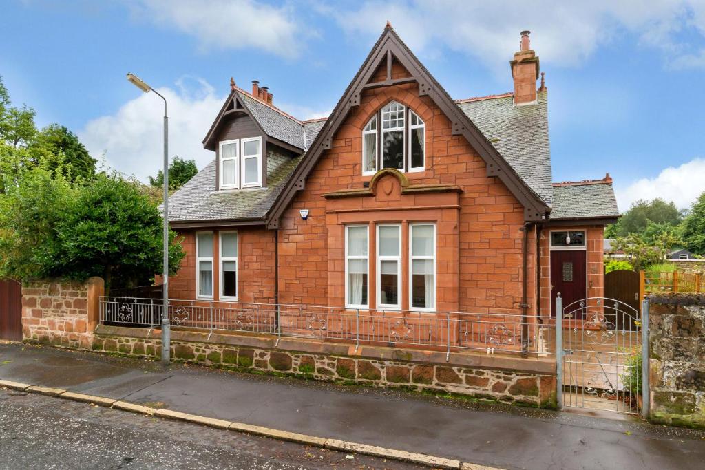 a red brick house on the side of a street at The Midsands Apartment in Ayr