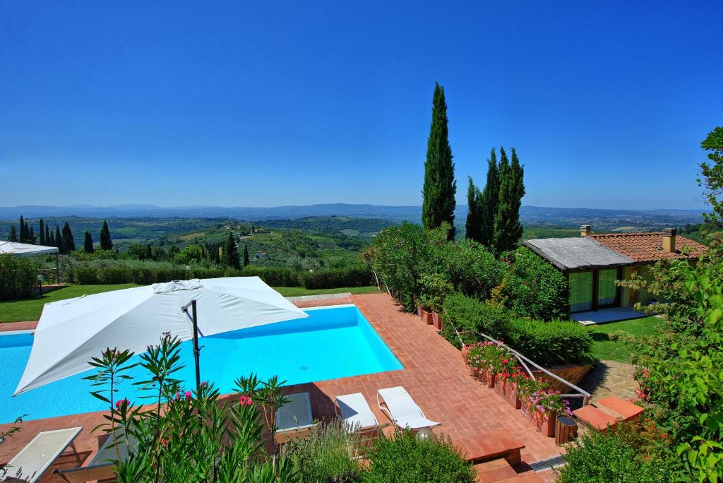 - Vistas al exterior de una villa con piscina y sombrilla en Villa Casa Lucia by PosarelliVillas, en Tavarnelle in Val di Pesa