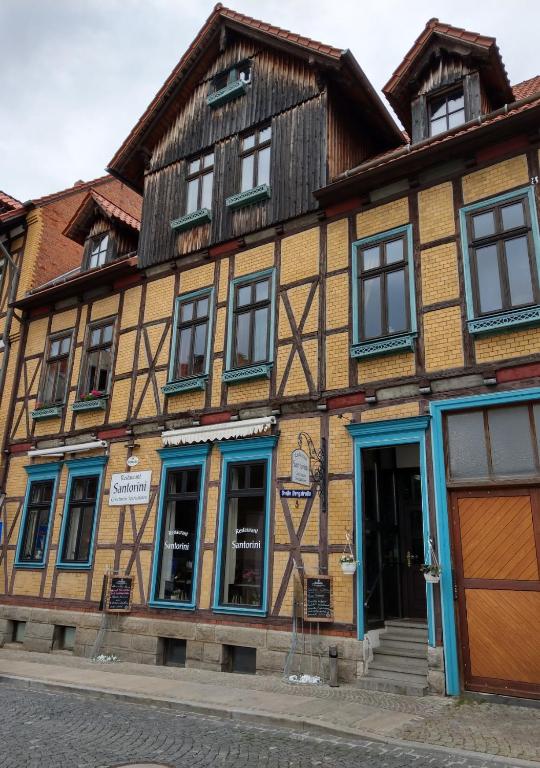 ein altes Gebäude mit blauen Fenstern auf einer Straße in der Unterkunft Ferienwohnungen Bergstrasse in Wernigerode