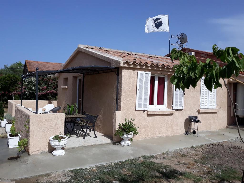 una pequeña casa con una mesa delante en L Appicciu, en Ventiseri