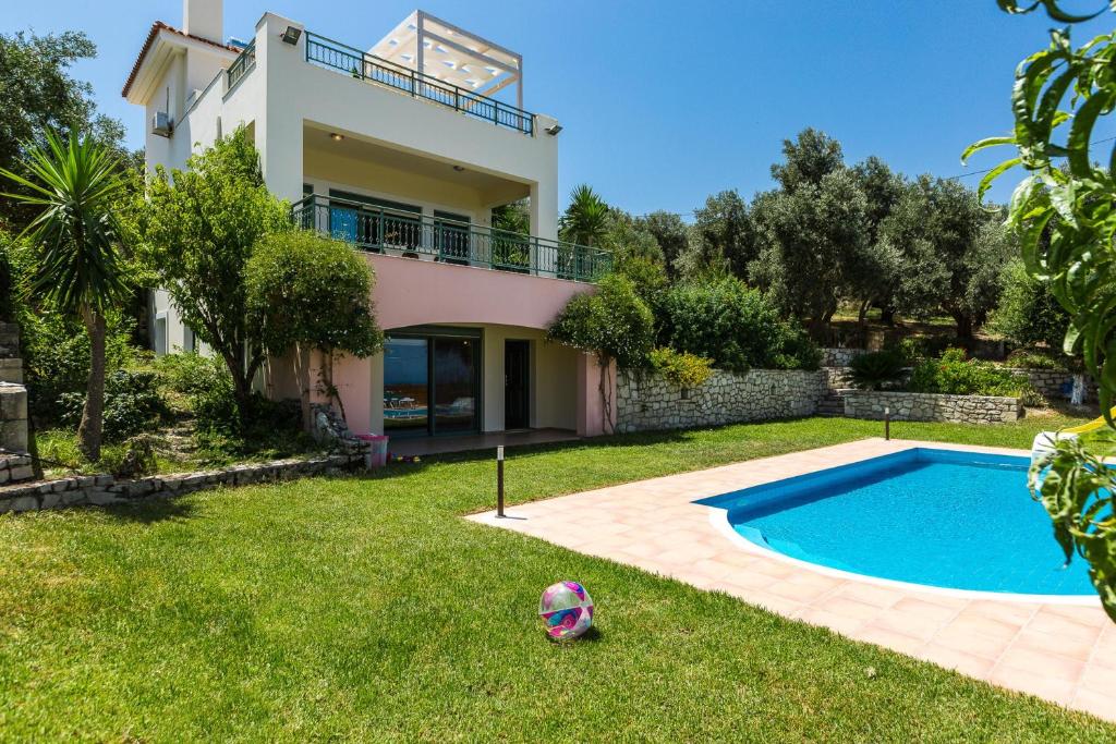 a house with a pool and a soccer ball in the yard at Archos Villa with Pool, Play Area,BBQ & Amazing View!! in Mési