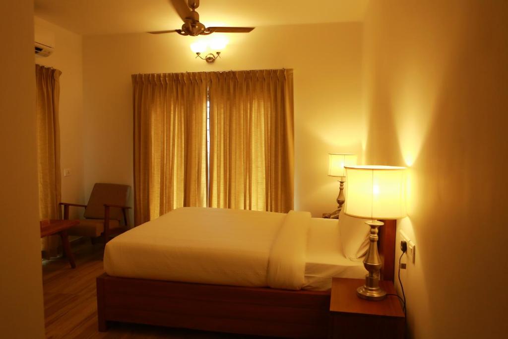 a bedroom with a white bed and a window at SOLO INN in Cochin