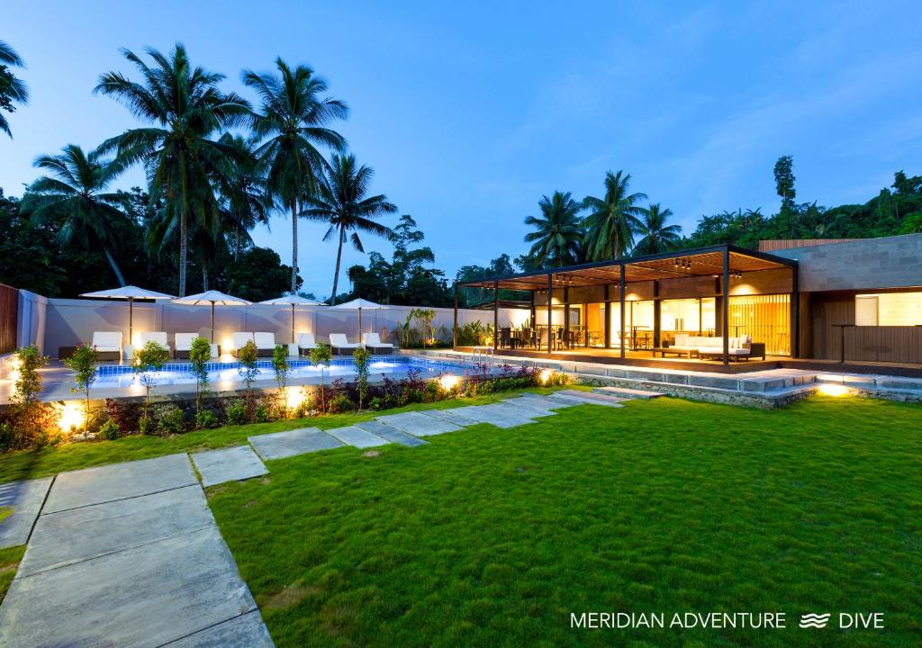 a house with a lawn in front of it at Meridian Adventure Marina Club & Resort in Saonek