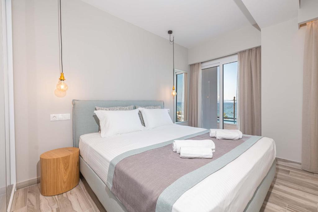 a bedroom with a large bed with two towels on it at Valtes Luxurious Apartments in Mpoukaris
