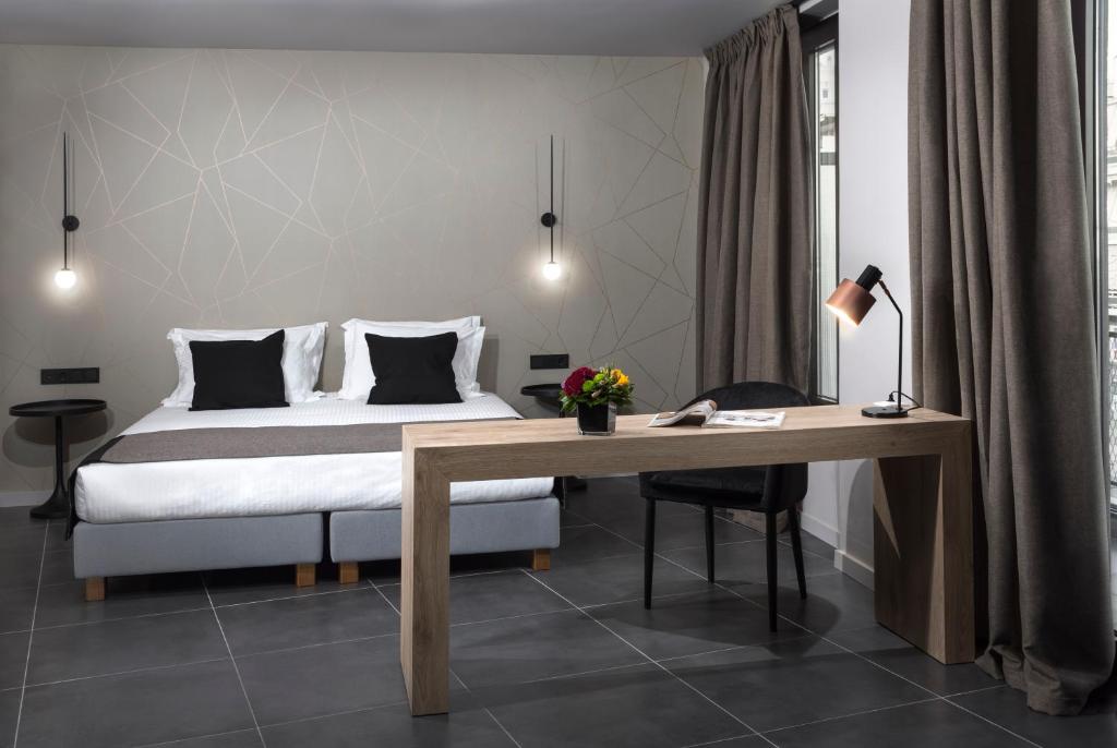 a bedroom with a bed and a desk with a desk at Azur Suites in Athens