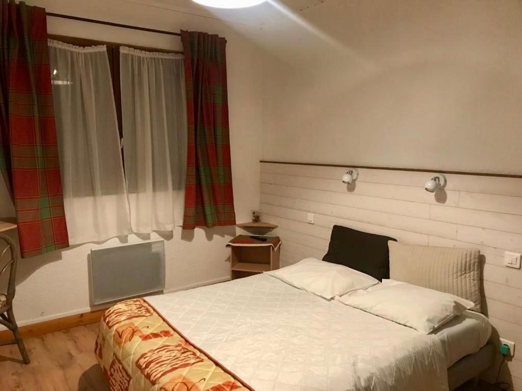 um quarto com uma grande cama branca em frente a uma janela em AUBERGE SAINT MICHEL em Saint-Martin-dʼUriage