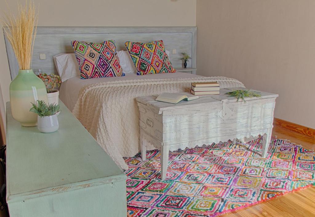 a bedroom with a bed and a table with books at Sabina Hotel in Arenas de San Pedro