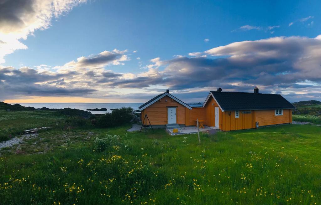 una casa en medio de un campo en Midnight Sun Lodge Lofoten, en Bøstad