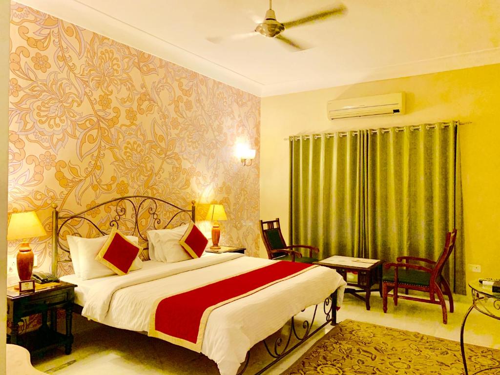 a bedroom with a bed with a red and white blanket at Suryaa Villa - A Boutique Heritage Hotel in Jaipur