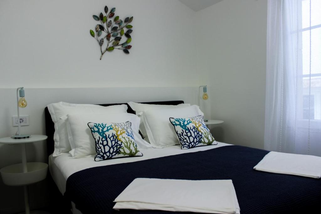 1 cama con almohadas blancas y colcha en blanco y negro en Sea Apartment Carera, en Rovinj