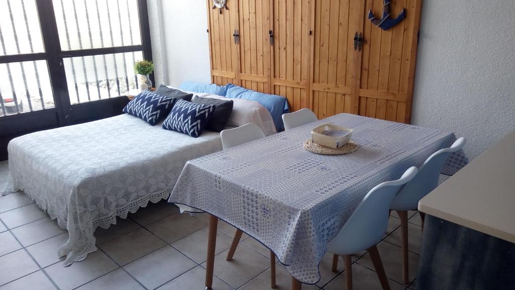 een kamer met een tafel en stoelen en een bank bij PILARSEVAHOME-APARTAMENTO MARINERO in Santa Pola