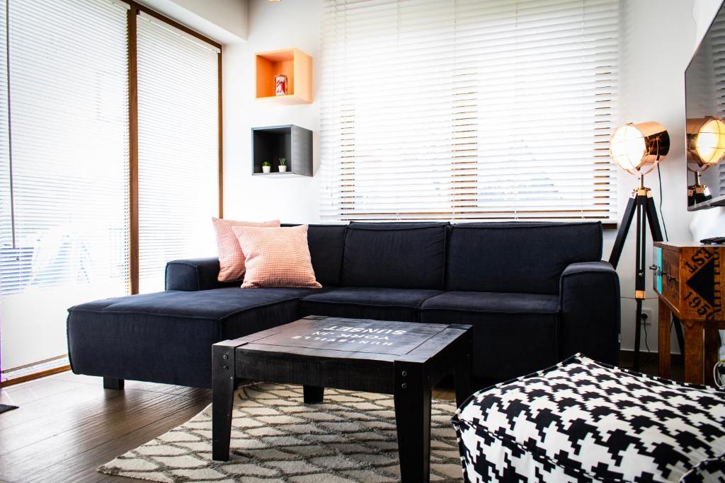 a living room with a blue couch and a table at Dream LUX Apartments in Kraków