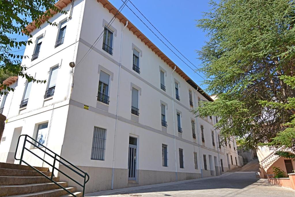 a large white building with stairs in front of it at Apartamentos en la Montaña - Fuente en Segures in Benasal