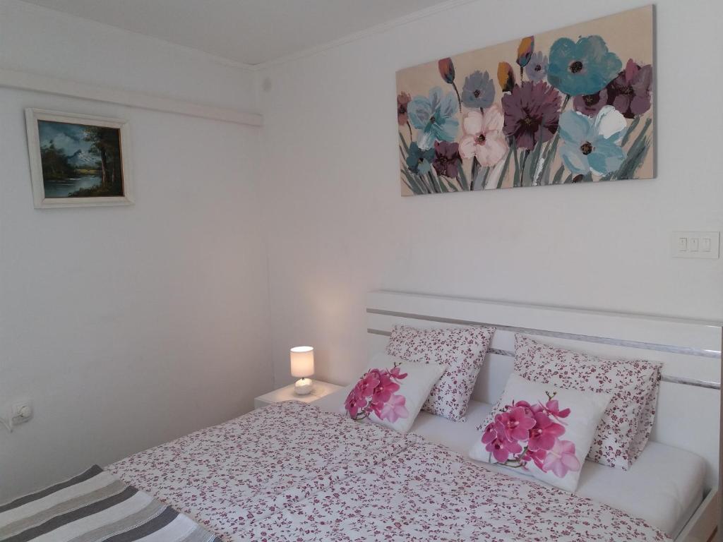 Schlafzimmer mit einem Bett mit rosa und weißen Kissen in der Unterkunft Flower Double Room SPLIT - Dugopolje in Dugopolje
