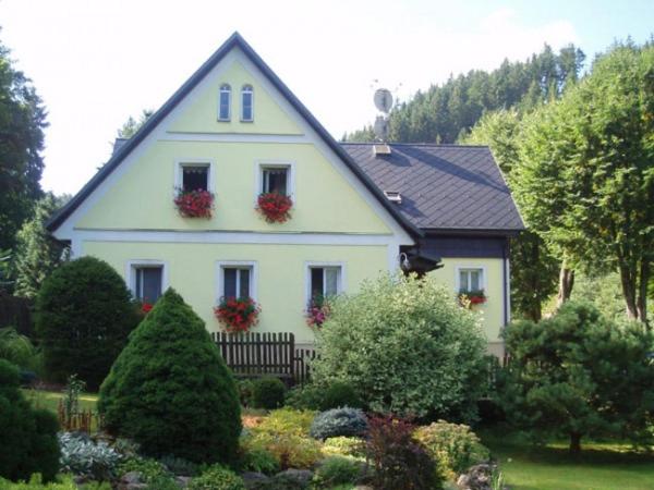 ein weißes Haus mit Blumenkästen an den Fenstern in der Unterkunft Pension Dita - Adršpach in Teplice nad Metují