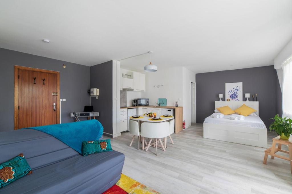 a living room with a blue couch and a bedroom at Nice studio with balcony and parking in Villeurbanne near Lyon - Welkeys in Villeurbanne