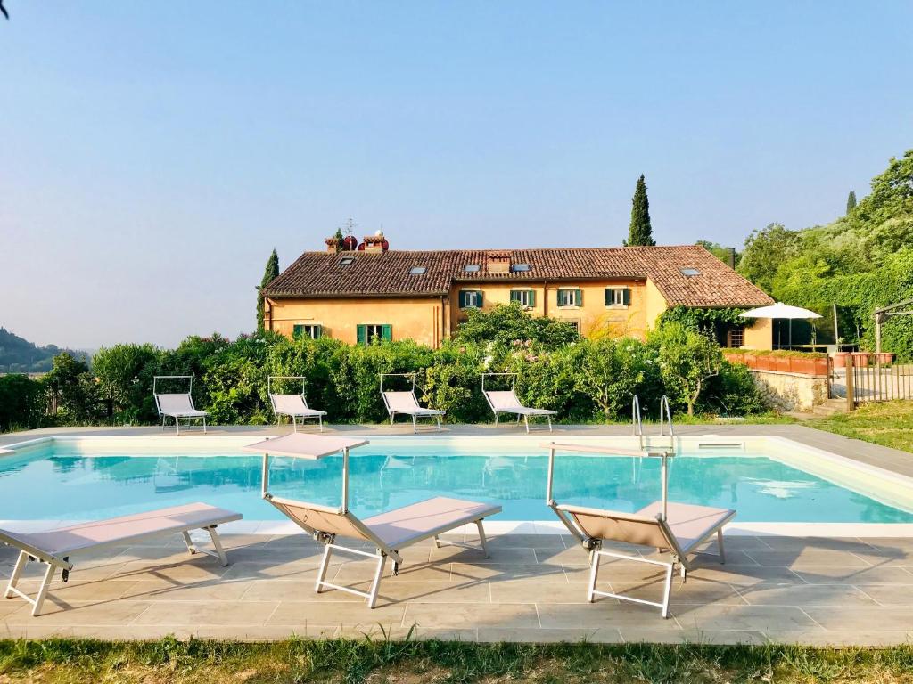 uma piscina com cadeiras e uma casa ao fundo em Villa Avesa em Verona