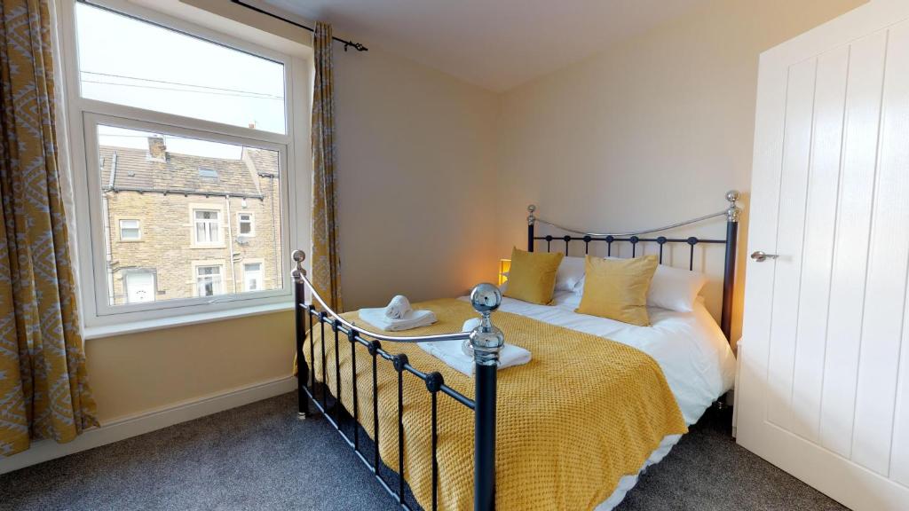 1 dormitorio con cama y ventana grande en StayZo Westminster Stylish House Accommodation en Bradford