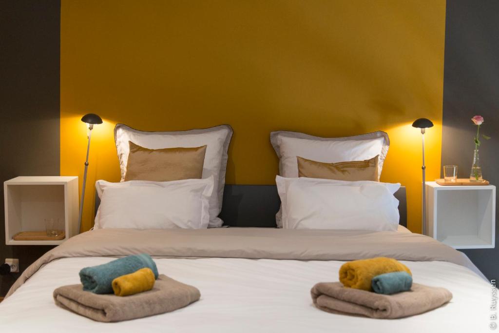 een slaapkamer met een bed met 2 kussens erop bij Les Petits Secrets de Nonna-Chambre d hote dinant in Flavion