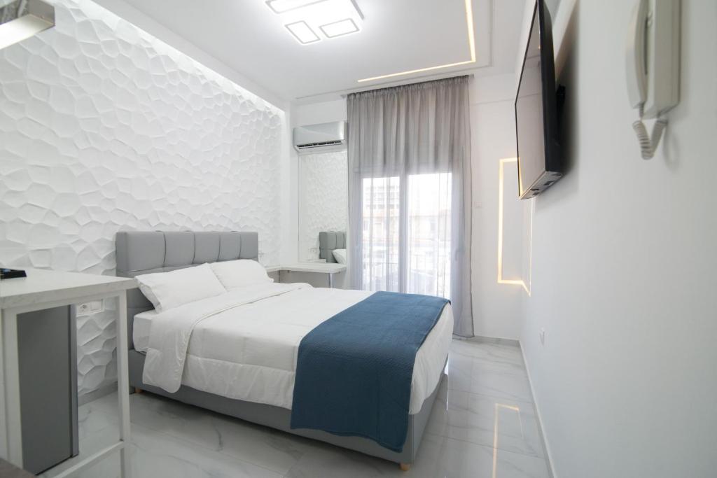 een slaapkamer met een bed, een bureau en een televisie bij Petite Palace Aristotelous 3 in Thessaloniki