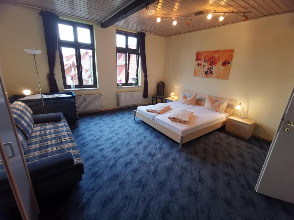 een slaapkamer met een wit bed en een bank bij Ferienwohnungen Bergstrasse in Wernigerode