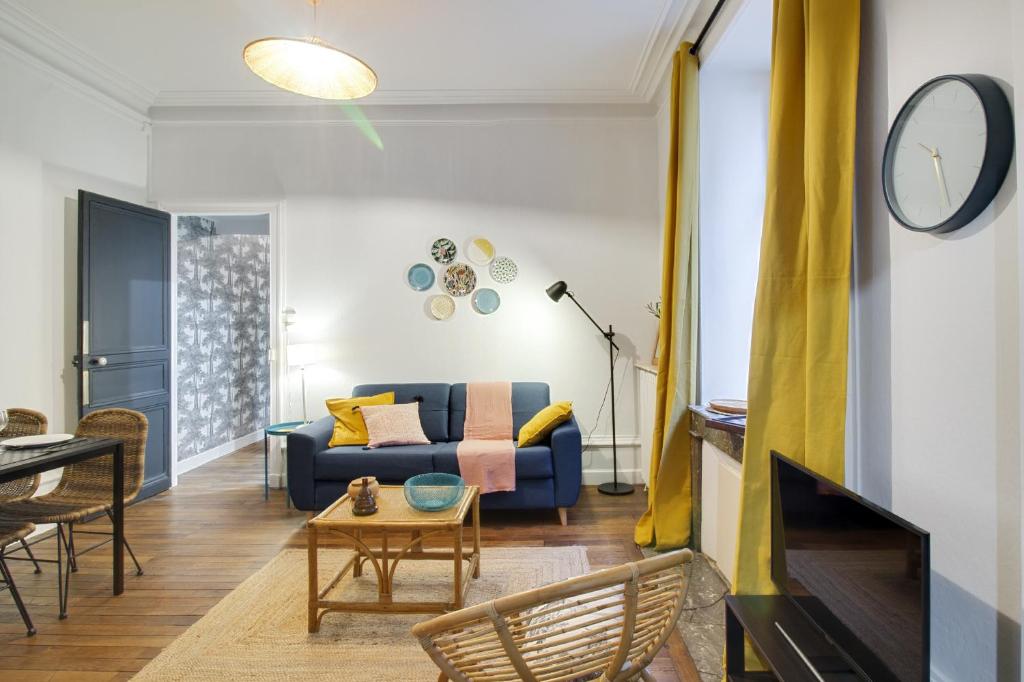 un salon avec un canapé et une table dans l'établissement Sous Le Cèdre - Au cœur de Nantes, à Nantes