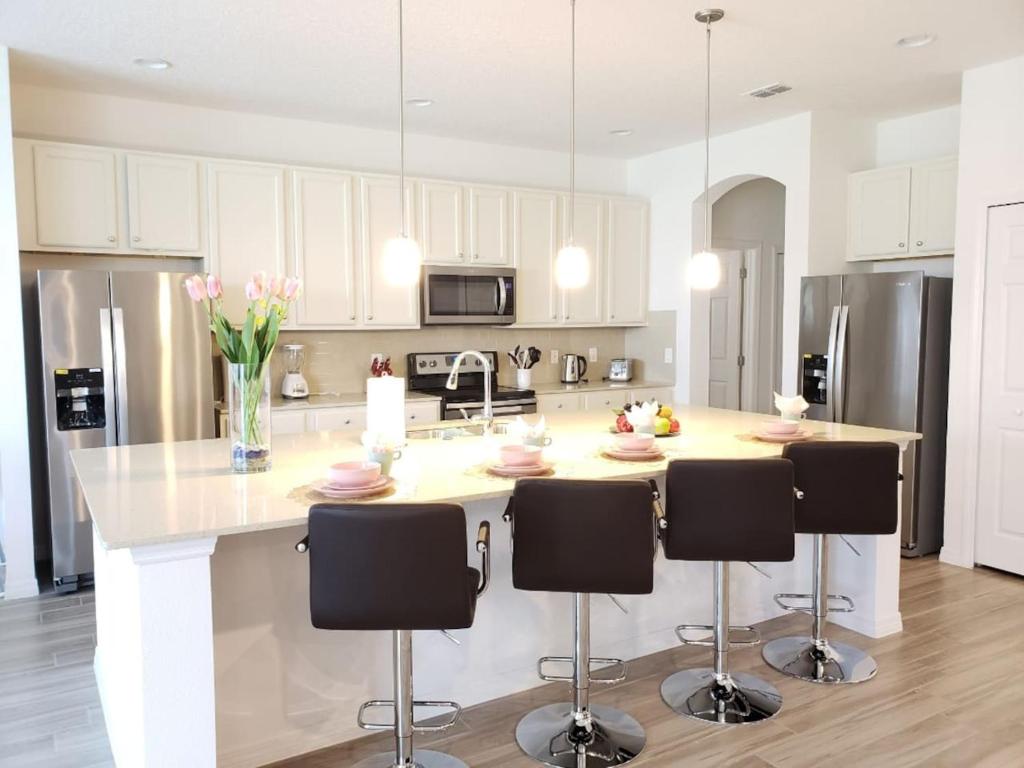 a kitchen with a large island with bar stools at G7009-New House Disney-Universal Studios in Davenport