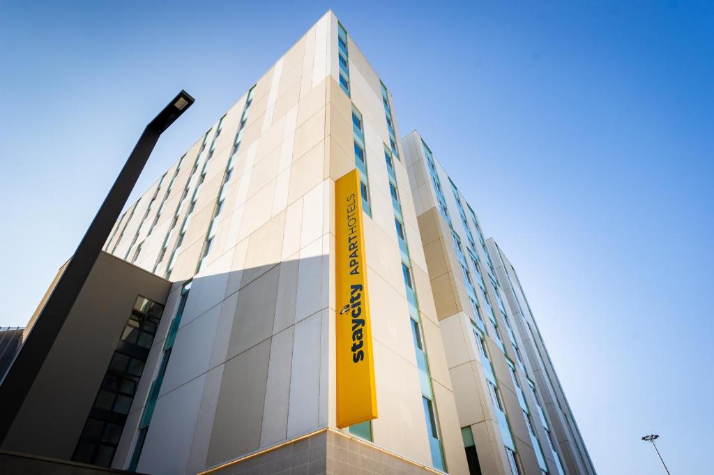 a building with a yellow sign on the side of it at Staycity Aparthotels Venice Mestre in Mestre