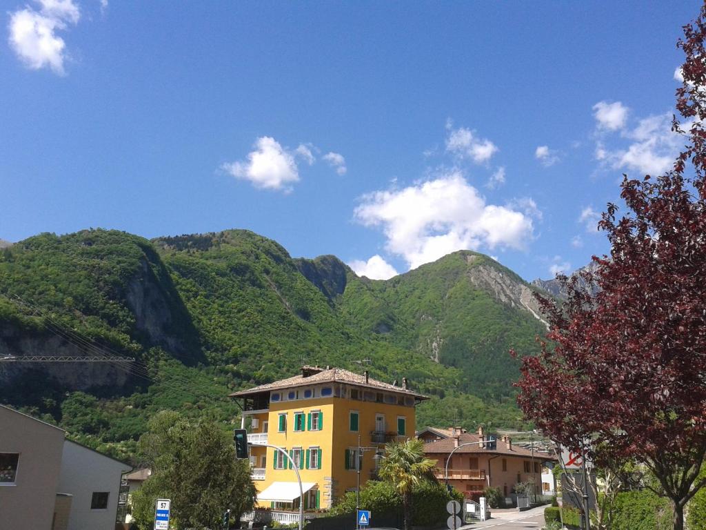 een geel gebouw voor een berg bij Agritur Tenno Cantina Bio Natura in Tenno