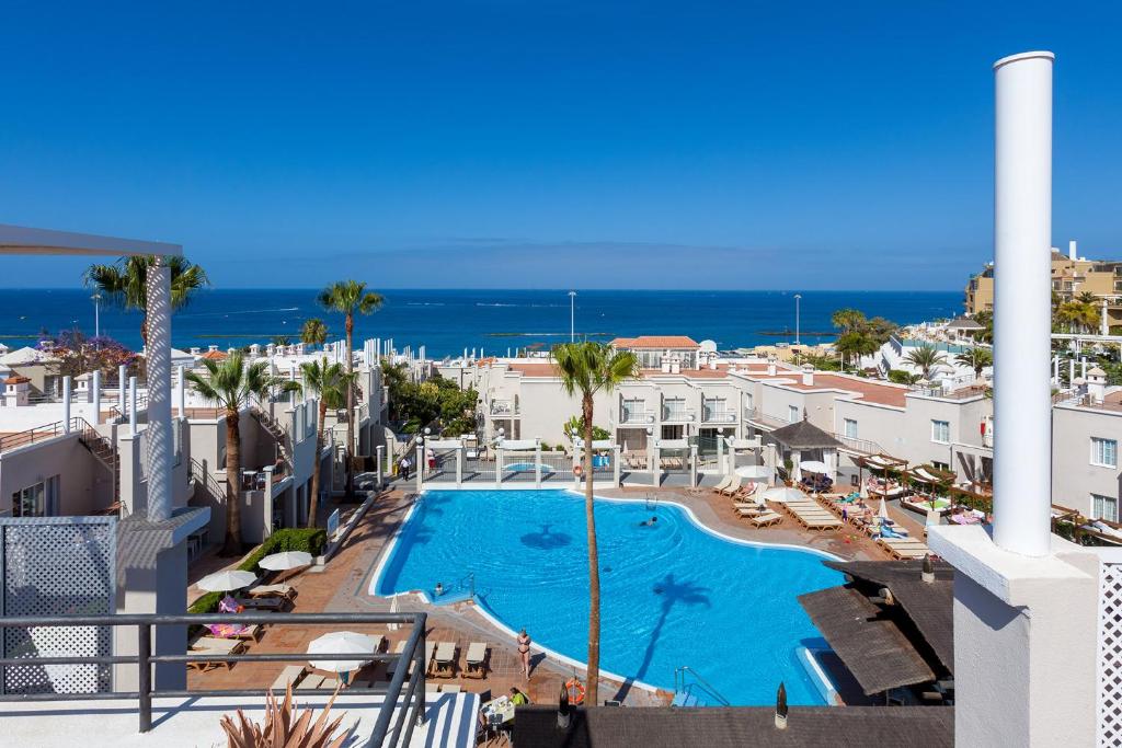 uma vista para a piscina a partir da varanda de um resort em Los Olivos Beach Resort em Adeje