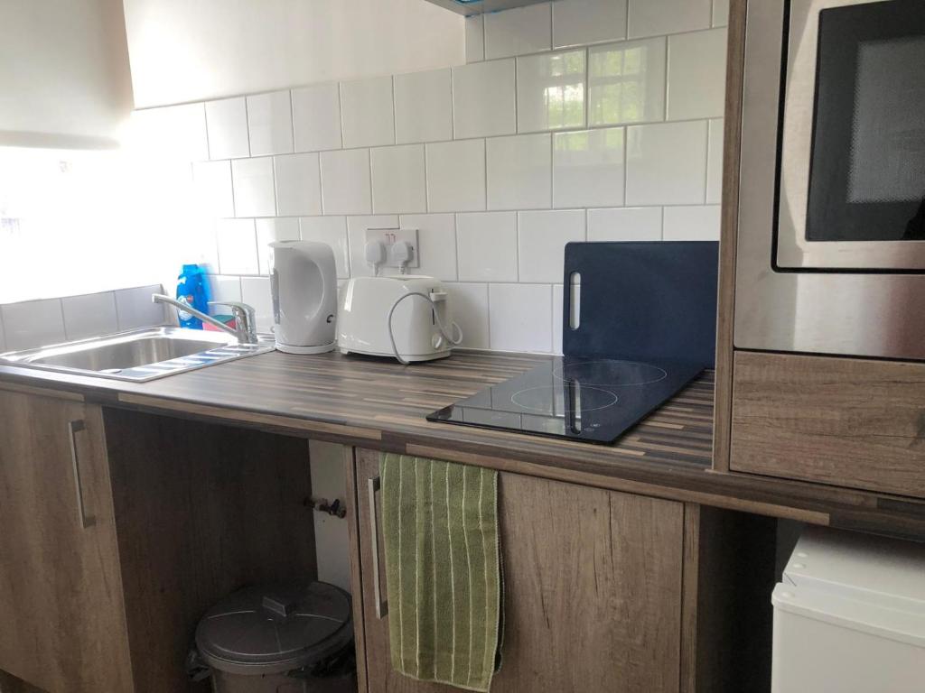 a kitchen counter with a sink and a microwave at Safe Move - 23 Lancaster House in Leicester
