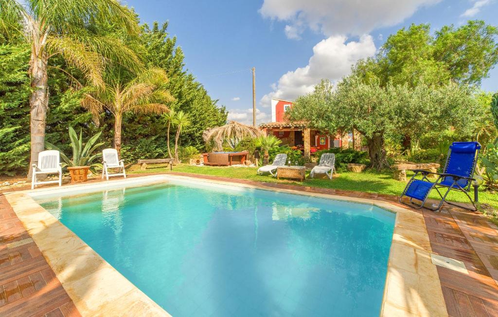 una piscina in un cortile con sedie e una casa di Casa Blandini a Menfi