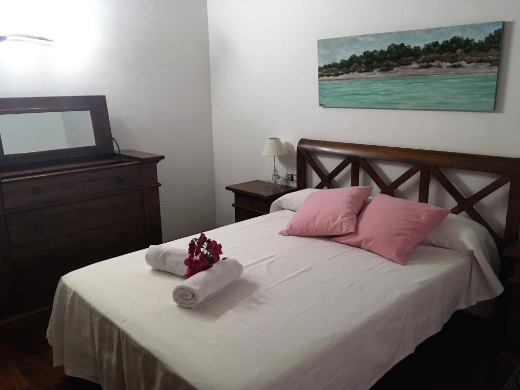 a bedroom with a bed with pink and white pillows at Villa para 6 con piscina privada. in Ciutadella