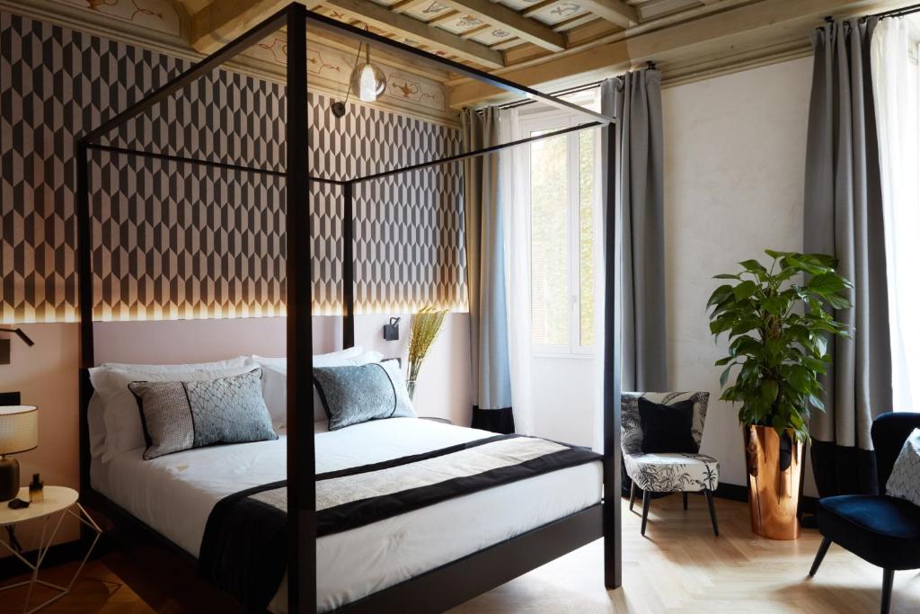a bedroom with a four poster bed and a plant at NAMAN HOTELLERIE - Margutta in Rome