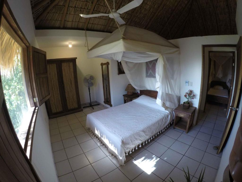 una camera da letto con un letto a baldacchino e un ombrello di Casa Aditi a Mazunte