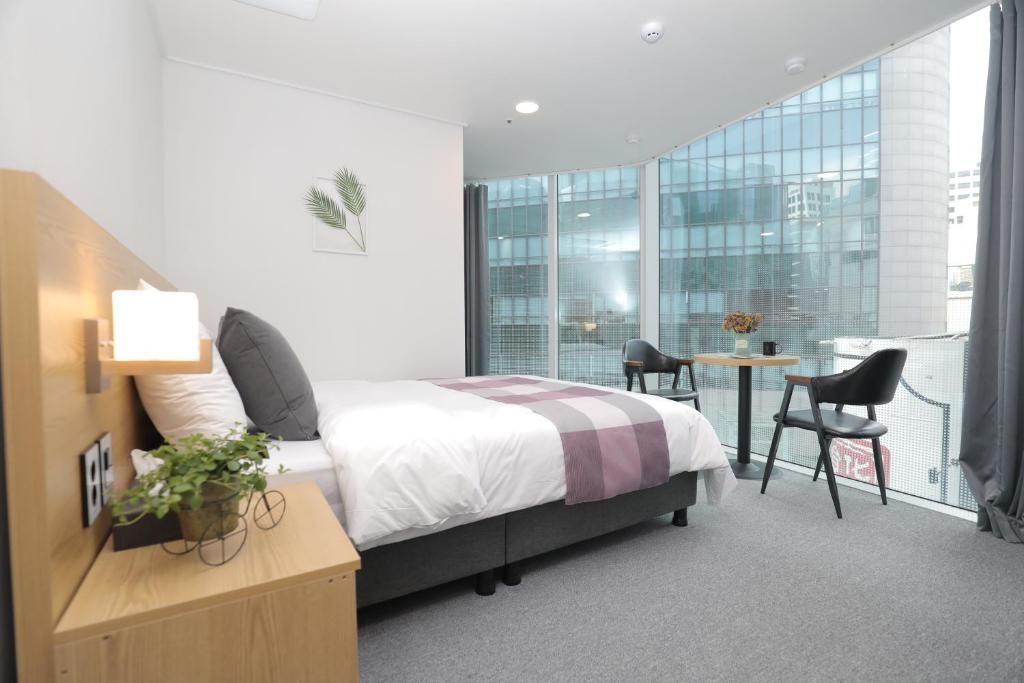 a bedroom with a bed and a table and chairs at Line Hotel Myeongdong in Seoul