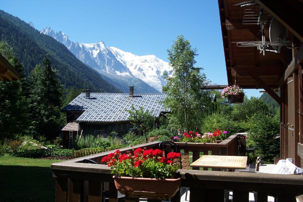 une maison fleurie sur un balcon avec une montagne dans l'établissement Chalet * Lioutraz *, à Chamonix-Mont-Blanc