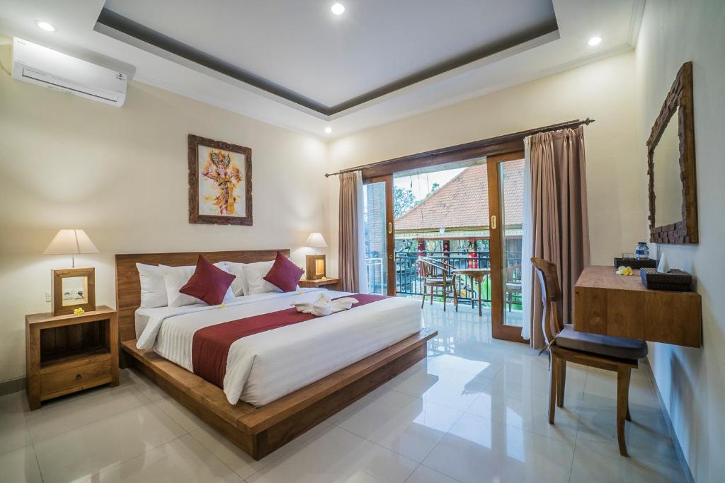 sypialnia z dużym łóżkiem i balkonem w obiekcie Sriwedari 40 Ubud w mieście Ubud
