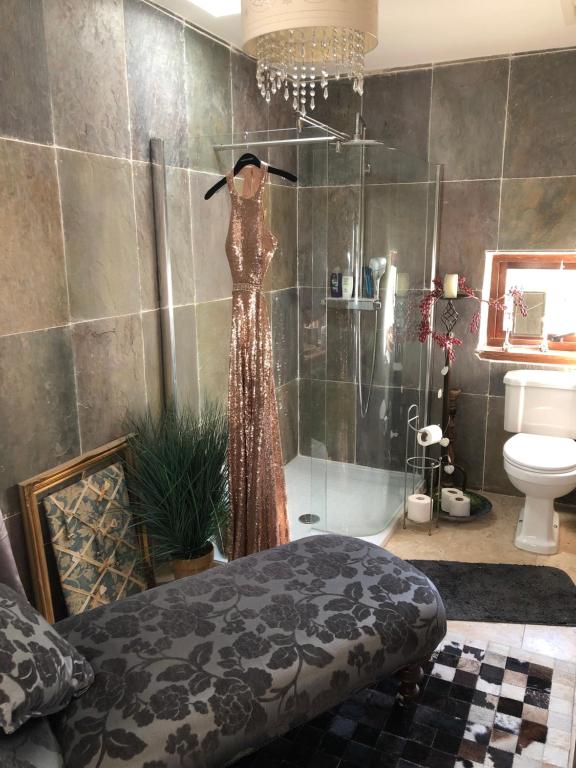 a dress on a mannequin in a bathroom at Belmont House Boutique - the Kingsley collection in Berwick-Upon-Tweed