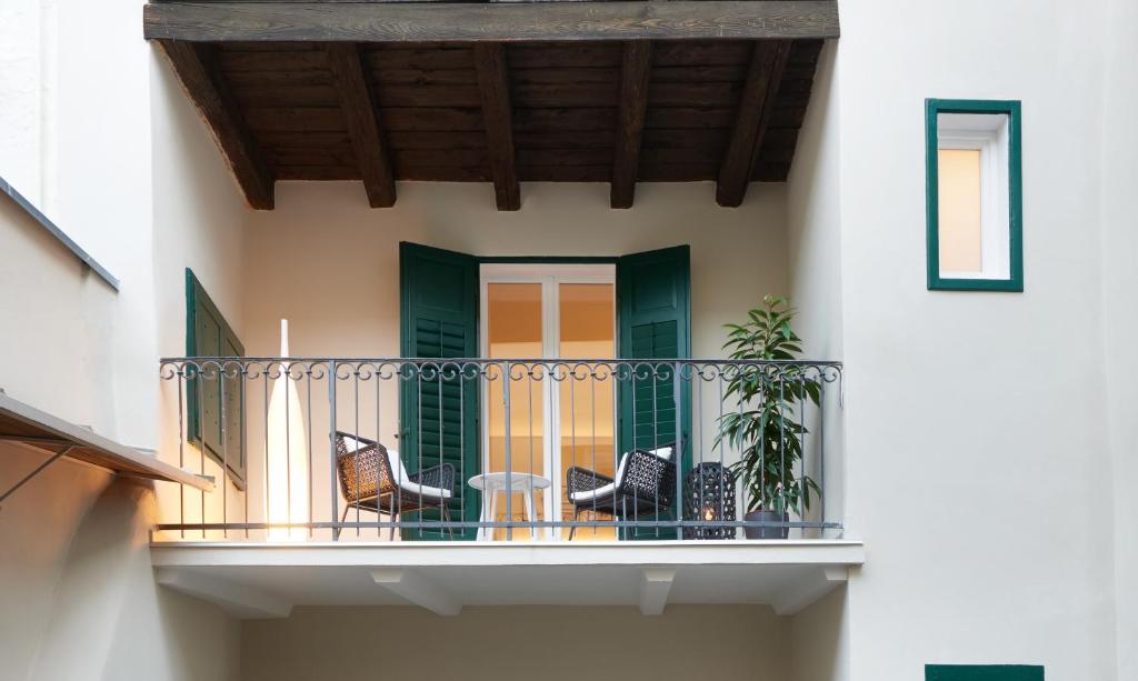 patio z krzesłami i stołem na balkonie w obiekcie Cityflair Boutique Apartments w mieście Bolzano
