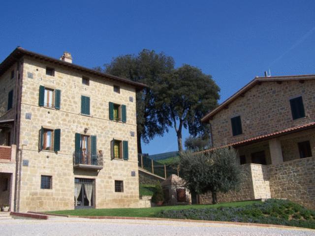 ein großes Steingebäude mit einem Baum im Hintergrund in der Unterkunft Agriturismo Ai Lecci in Ramazzano