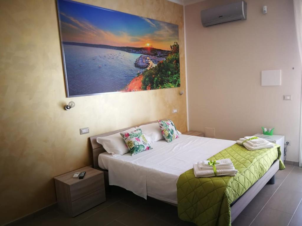 1 dormitorio con 1 cama y una pintura en la pared en Aden B&B Salento en Sannicola