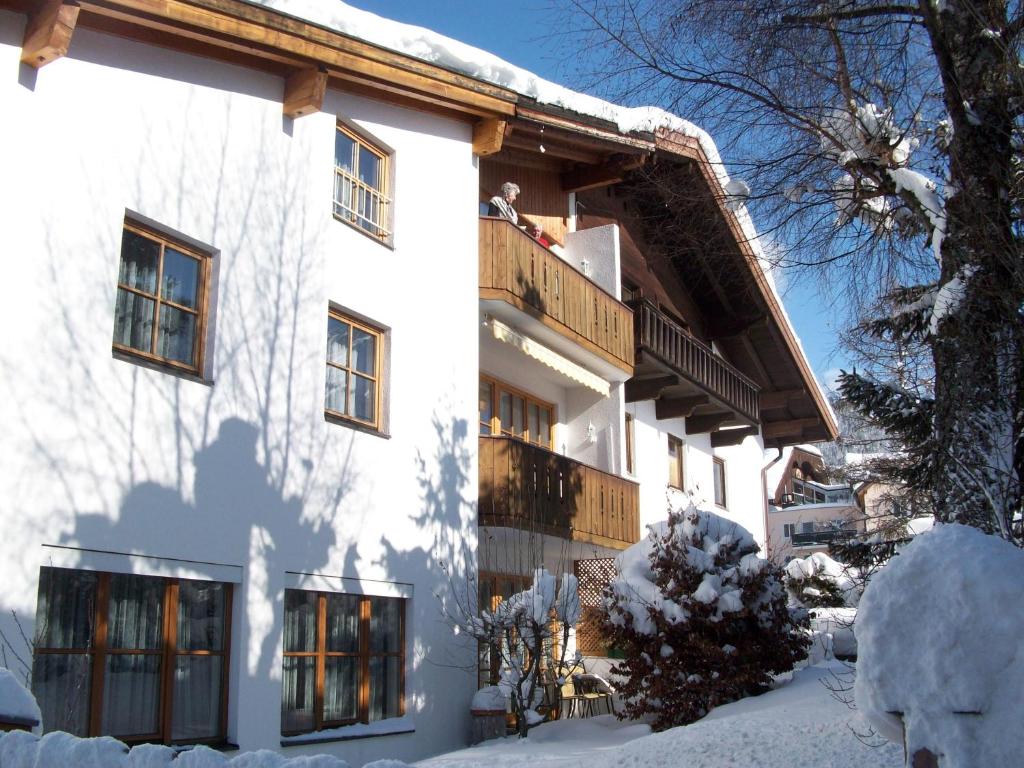 a white building with a balcony in the snow at Haus Fuchs in Ehrwald