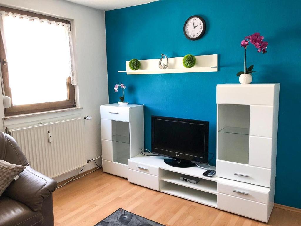a living room with a tv and a blue wall at Gemütliche Fewo Angela 5 im Westerwald in Bad Marienberg