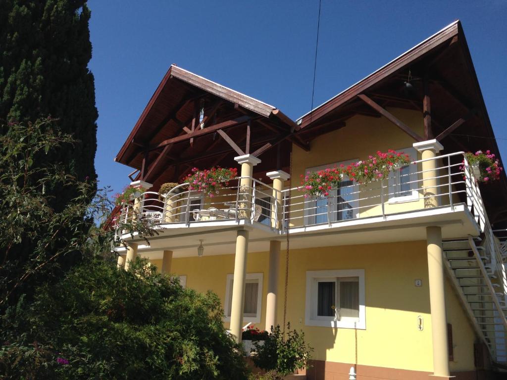 ein Haus mit Balkonen und Blumen darauf in der Unterkunft Villa Natalia in Hévíz